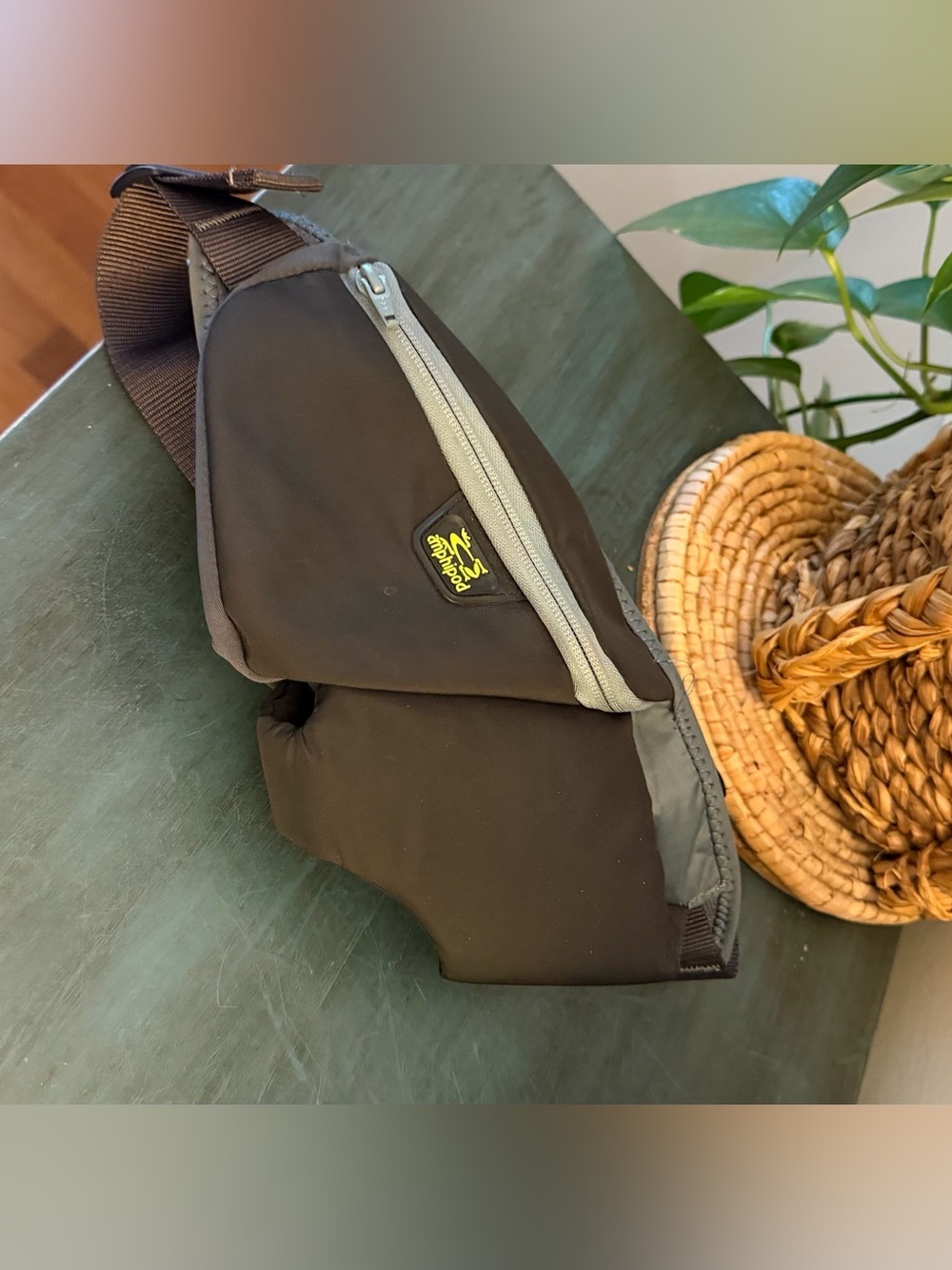 Amphipod runner’s waist pack with gray and black design with yellow logo.